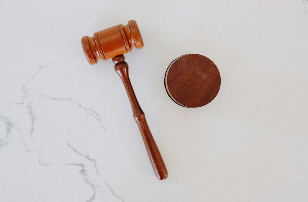 A wooden gavel and a brown container on top of a table.